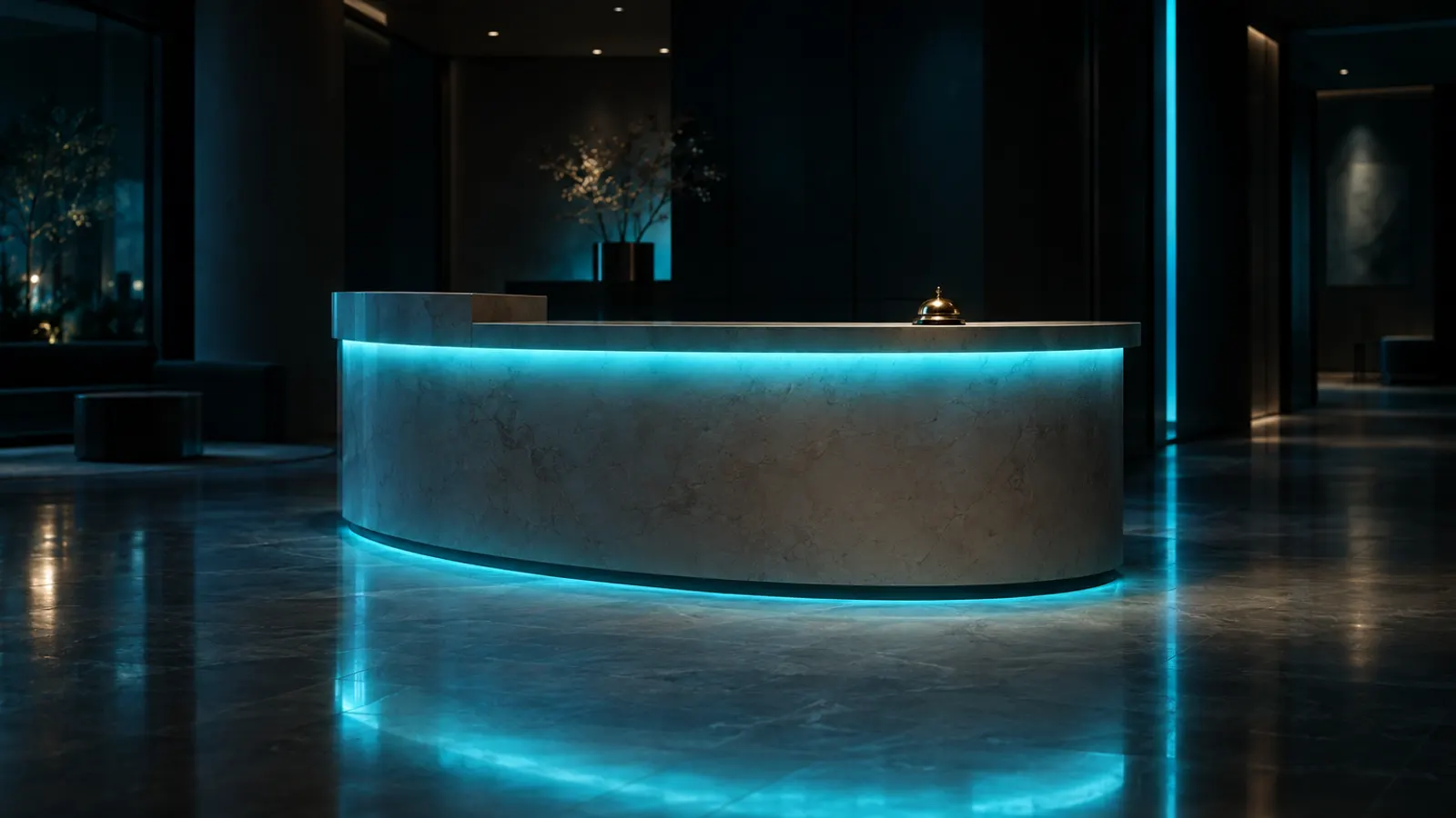 An empty reception counter at night with a brass desk bell and a cyan light along its edge.